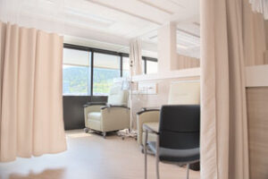 Chemotherapy treatment chairs with additional seating for loved ones and curtains for privacy 